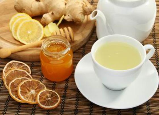 Ginger tea with honey and lemon on a bamboo napkin.